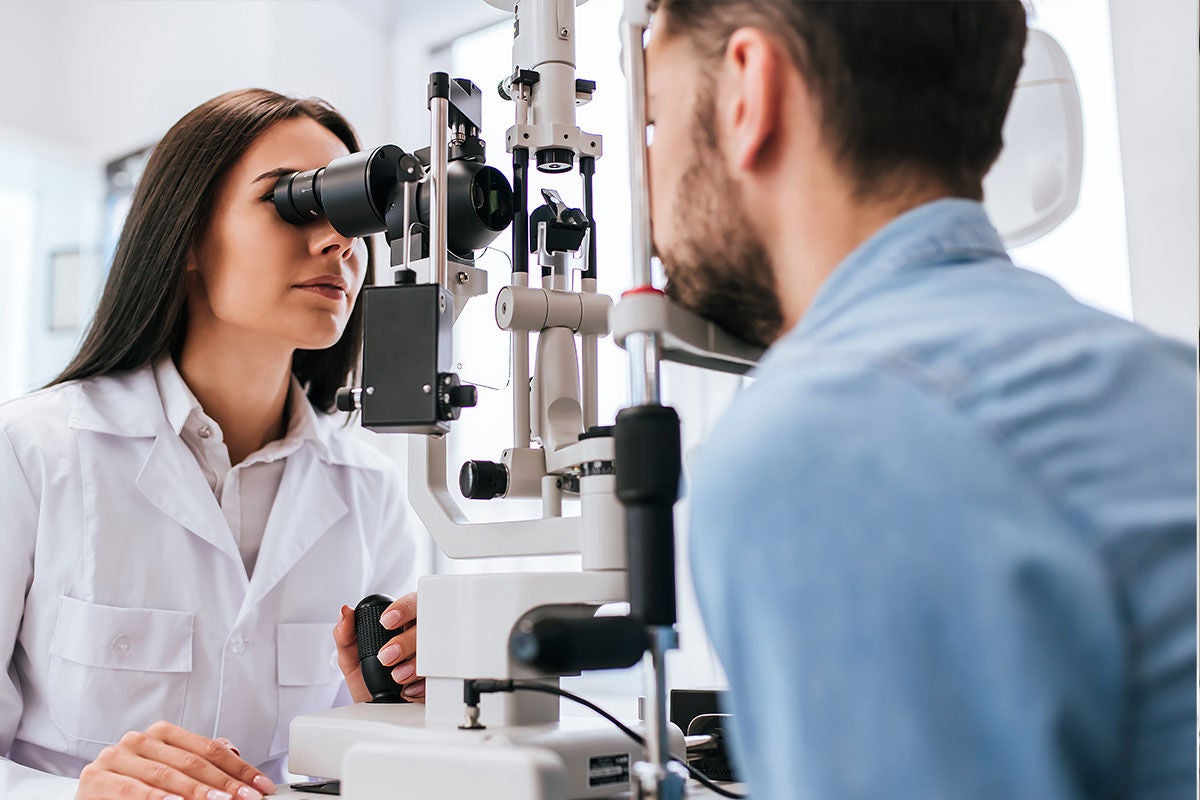 optometrist performing eye exam on man