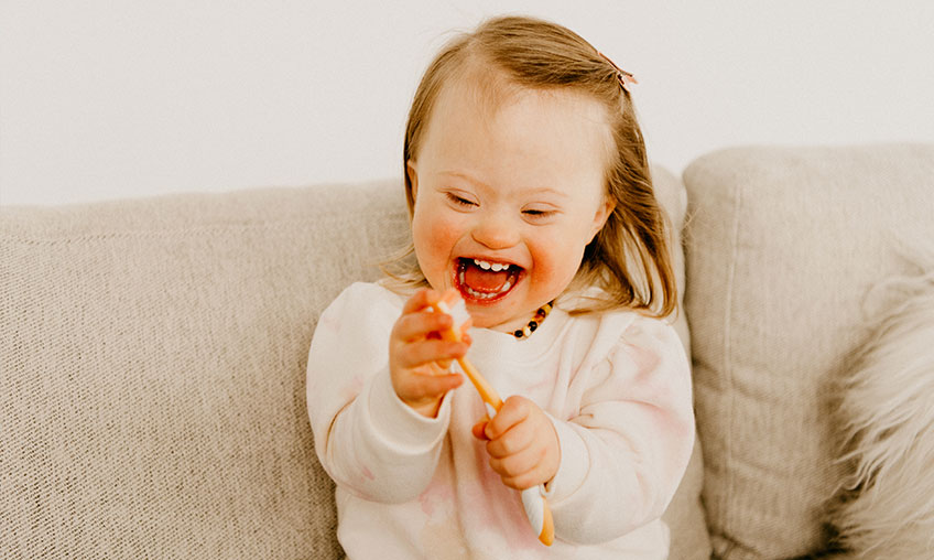 niño con discapacidad jugando con su cepillo de dientes