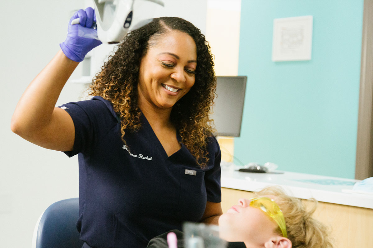 African American dentist examining child in office