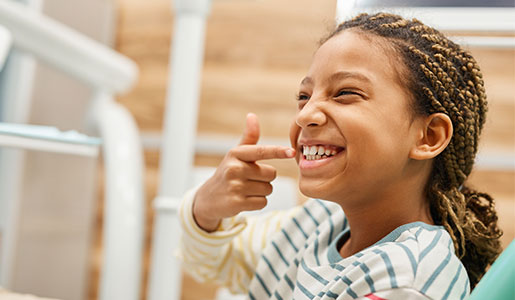 Niña examinando felizmente su sonrisa