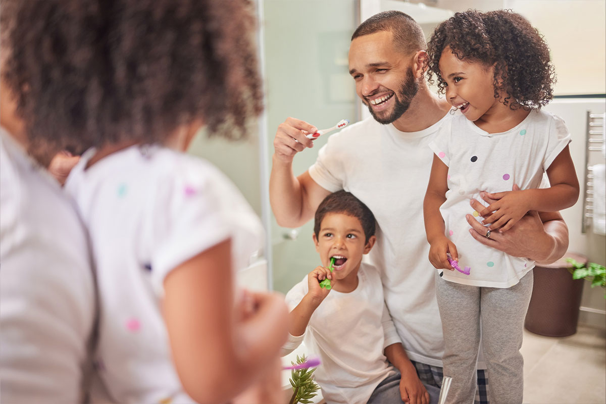 Familia cepillándose los dientes juntos